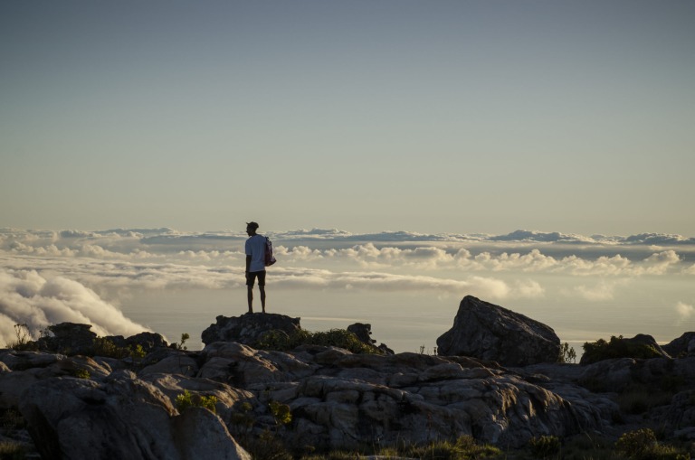 Ein Mann steht über den Wolken auf dem Tafelberg in Kapstadt, Südafrika