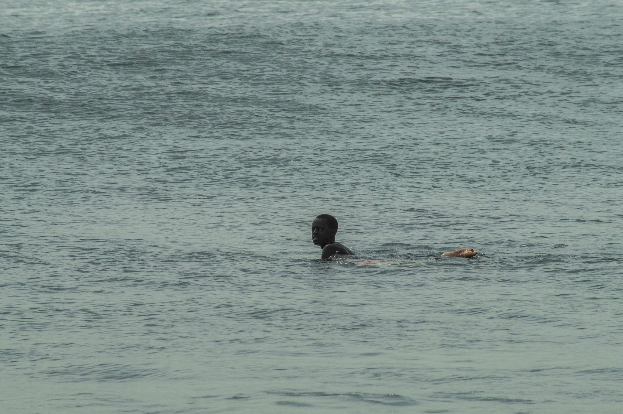 Ein Surfer im Meer vor Dakar