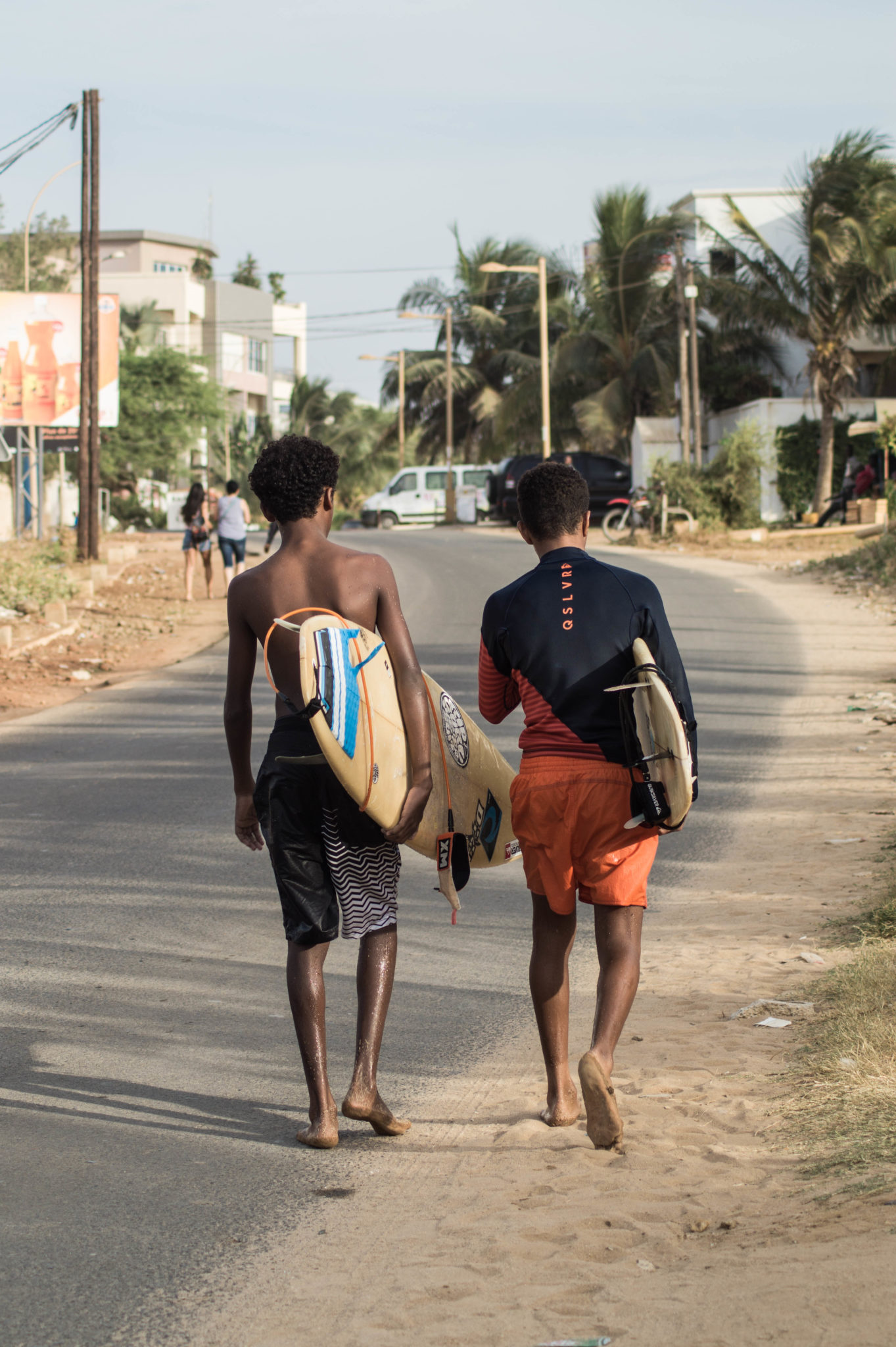 Surf Senegal: In den Straßen von Les Almadies sieht man oft junge Surfer, die mit ihren Surfbrettern nach Hause spazieren.