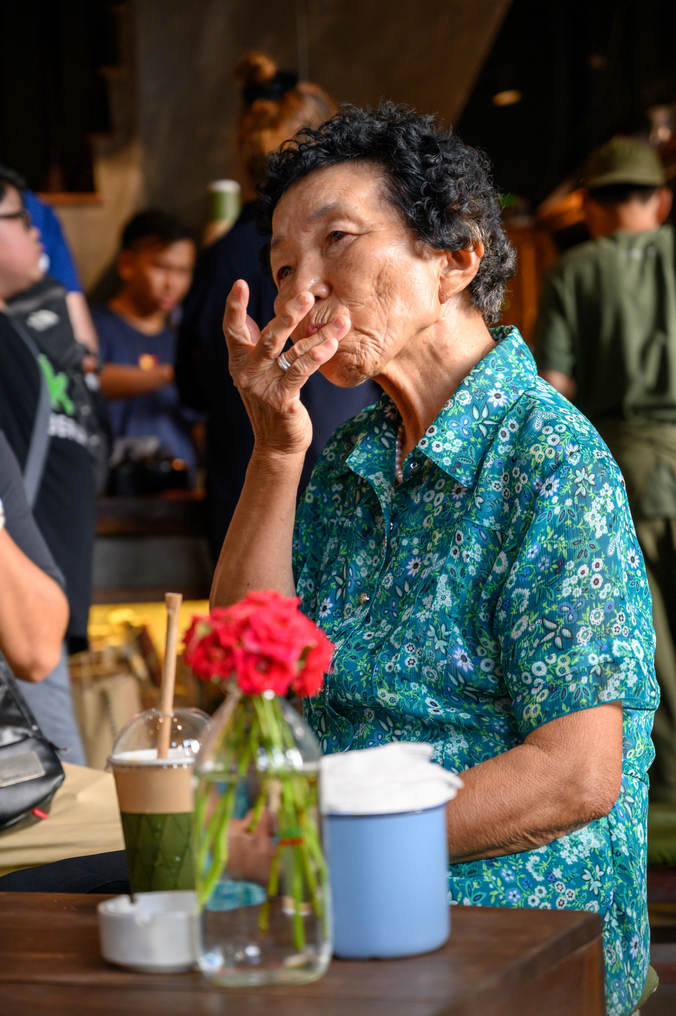 Eine alte Vietnamesin in einem Café im Old Quarter