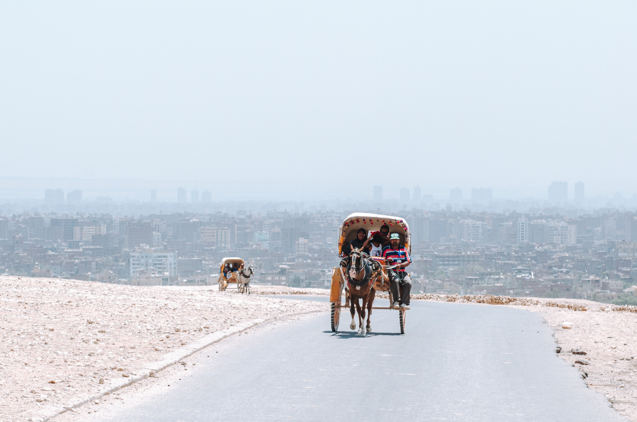 Kutschen in Gizeh vor der Skyline von Kairo