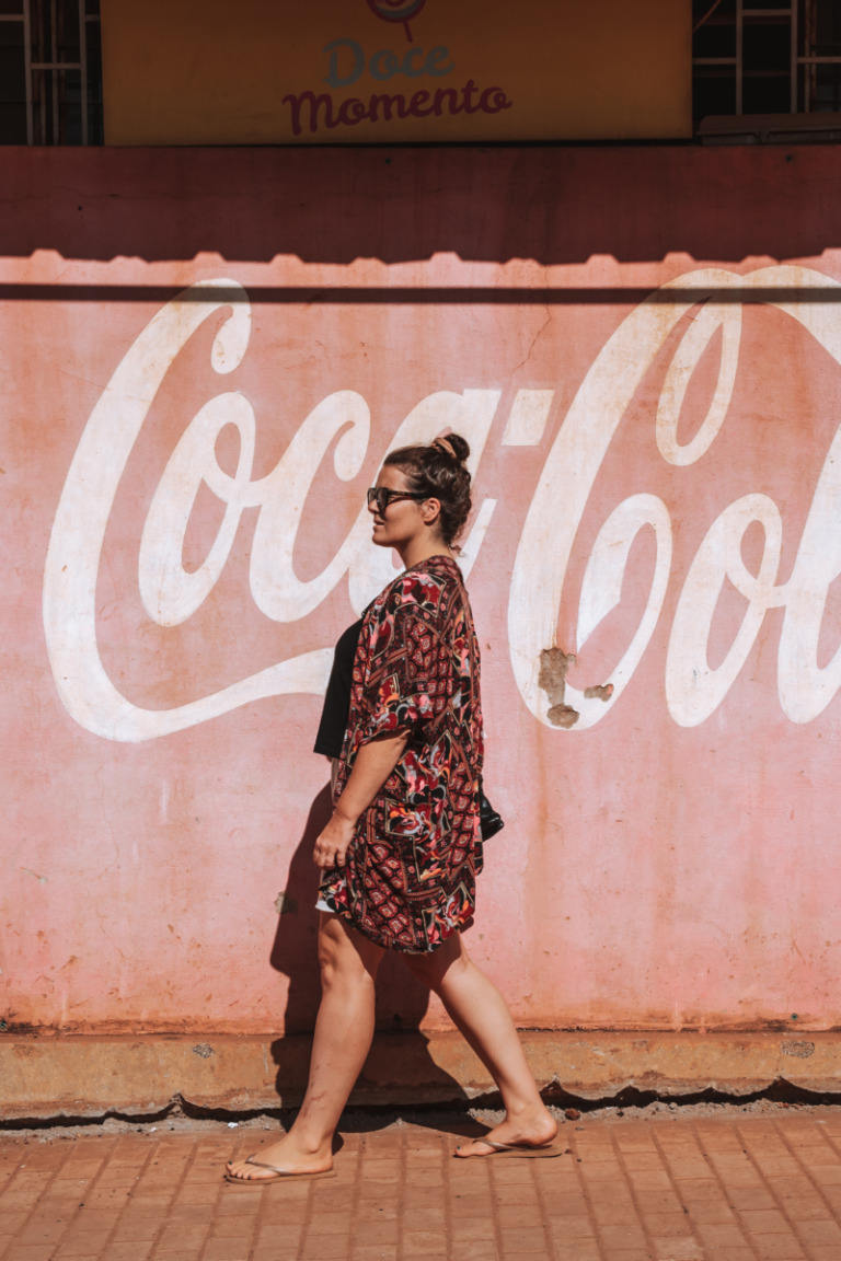 Anne vor einem Coca-Cola-Schild in Guinea-Bissau